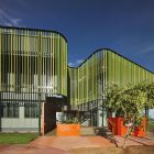 screen creates shaded, non-airconditioned spaces for people to work and gather, and at night the screen glows like a beacon across the town